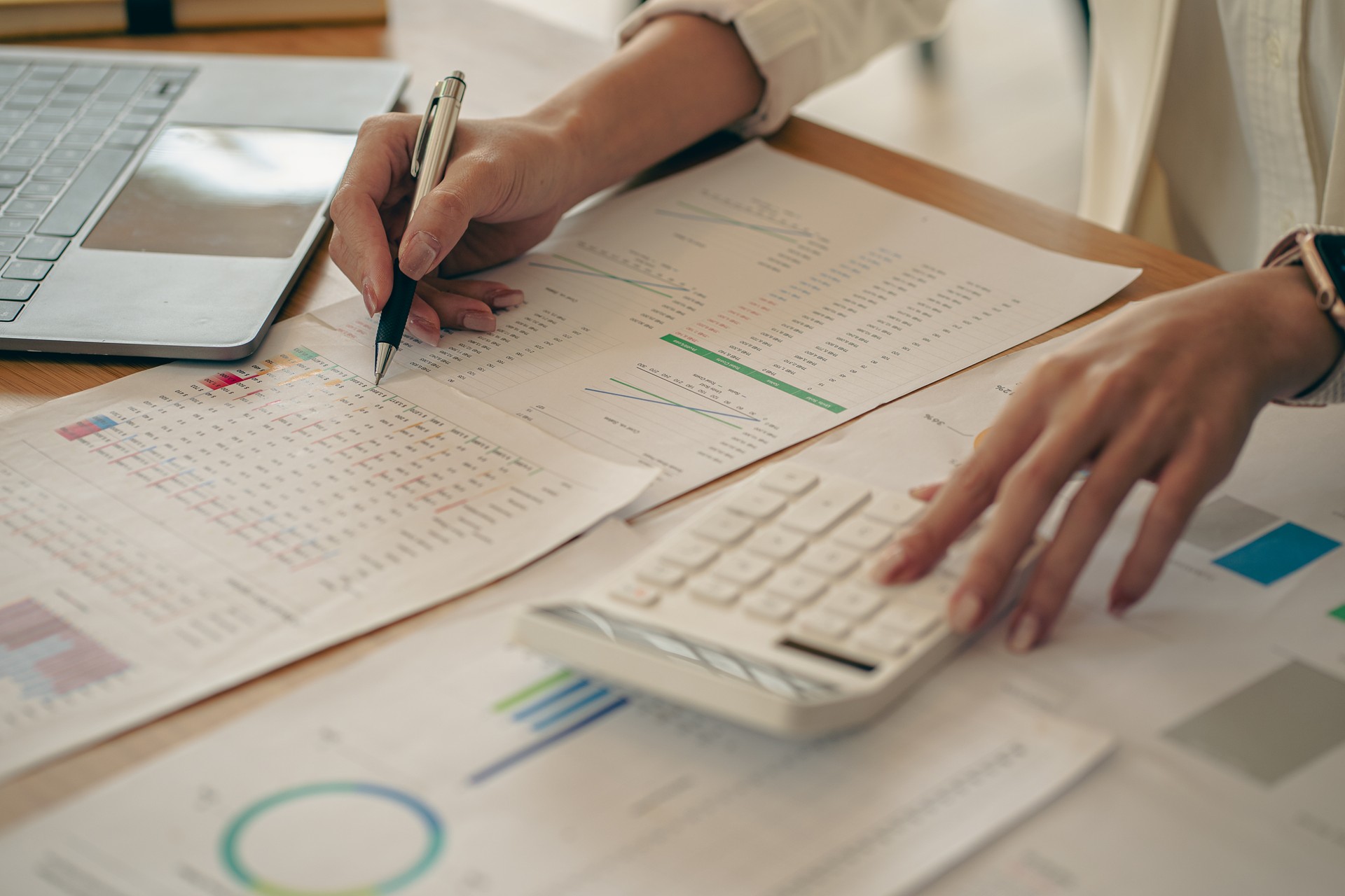 business office concept At her desk, a female accountant presses a calculator for a monthly financial report or company profit.